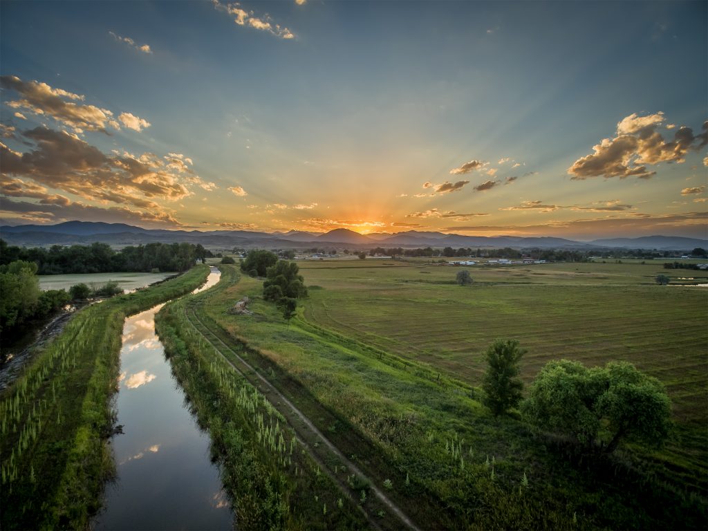 Sunset,Over,Rocky,Mountains,And,Foothills,With,An,Irrigation,Ditch